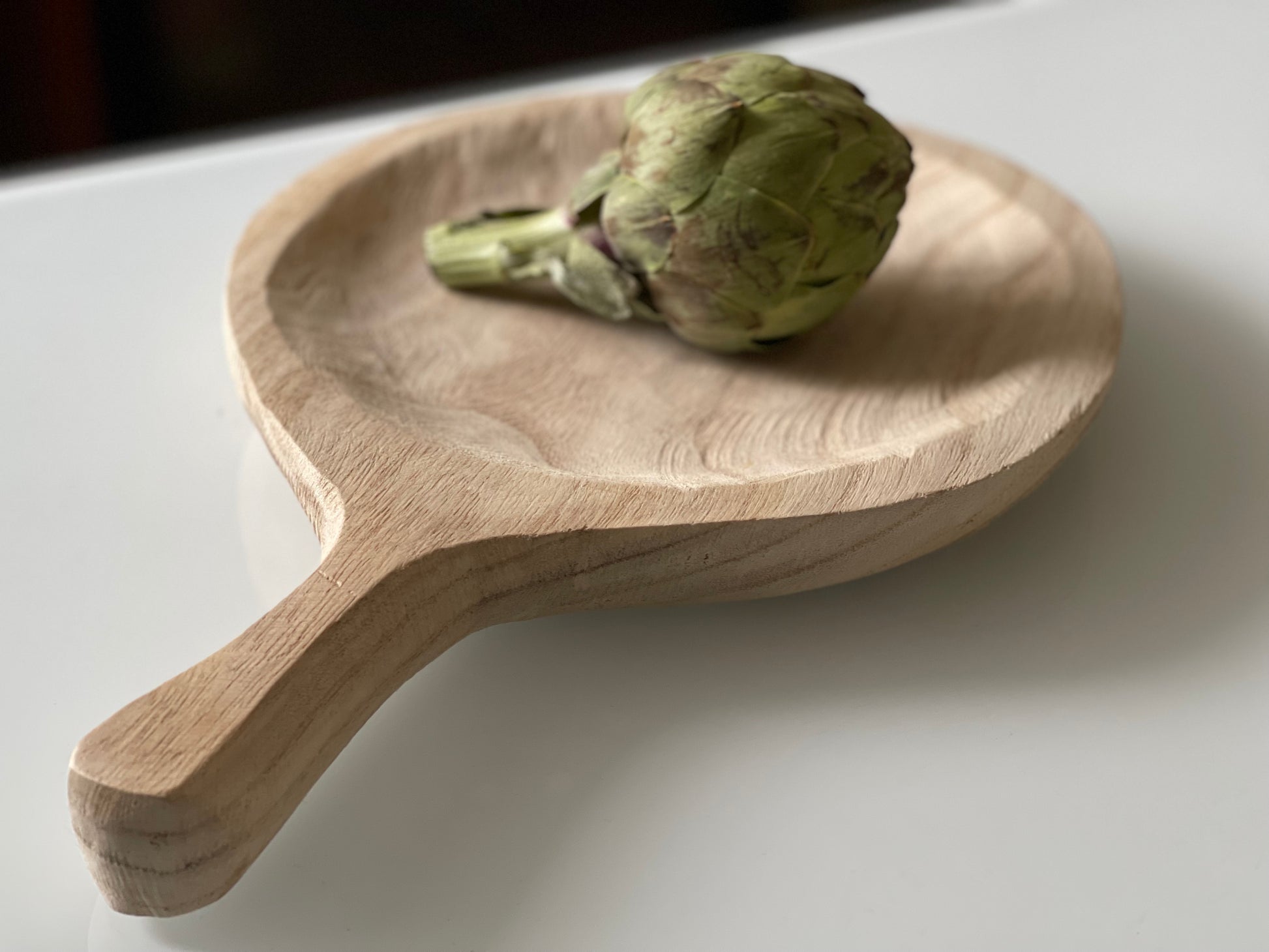 This hand-carved tray is made of 100% Paulownia wood. This wooden tray is round with a handle, which creates a natural and boho-chic style. This tray can be used in a variety of ways. The tray can be used as display area on a coffee table, holding fresh fruits and vegetables in the kitchen, or as a serving piece for a special occasion. Dimensions: 13-1/2"L x 9"W